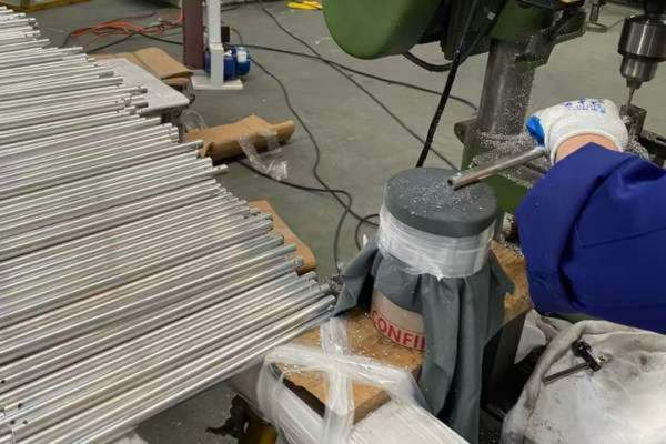 Multi-spindle drilling station punching lock-button holes into anodized telescopic pole tubes at Poolpole
