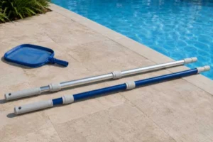 Aluminum pool pole and fiberglass pool pole compared beside a swimming pool