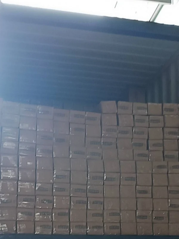 Retail cartons of 4-section aluminum poles being loaded into an export container