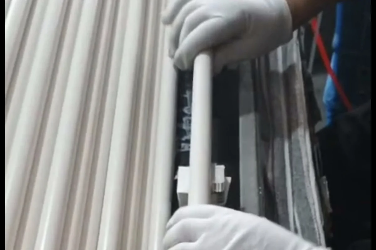 Worker assembling a custom push-button lock onto a 3-section aluminum pole at the Xingyong factory