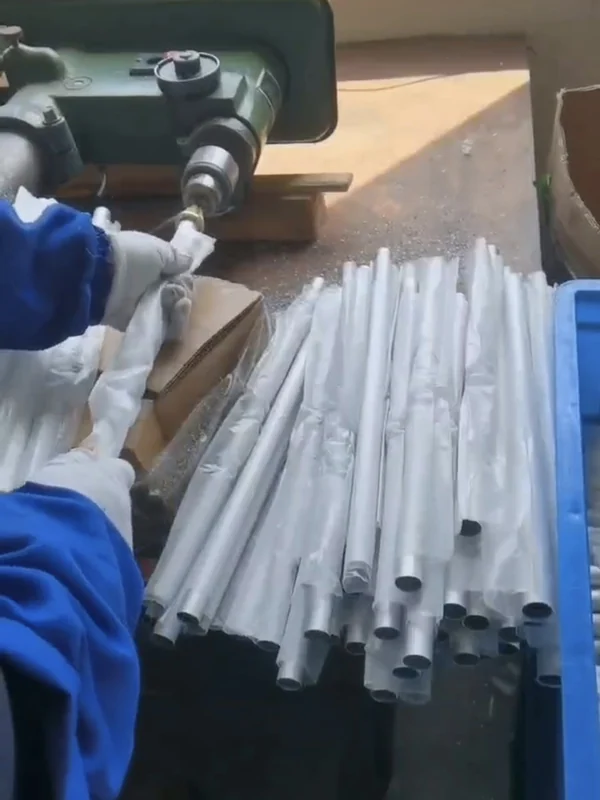 Machining and drilling the push-button seat on grey spray-coated aluminum pole tubes