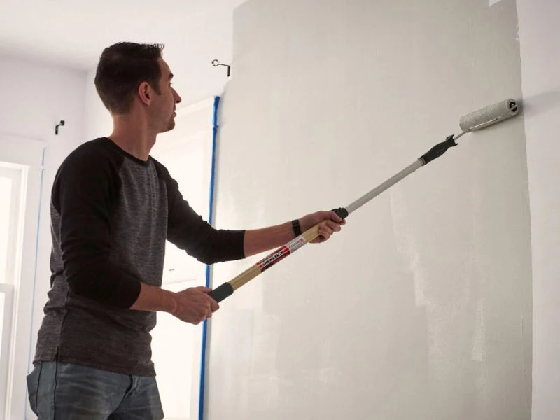 20 ft paint roller extension pole reaching a stairwell ceiling