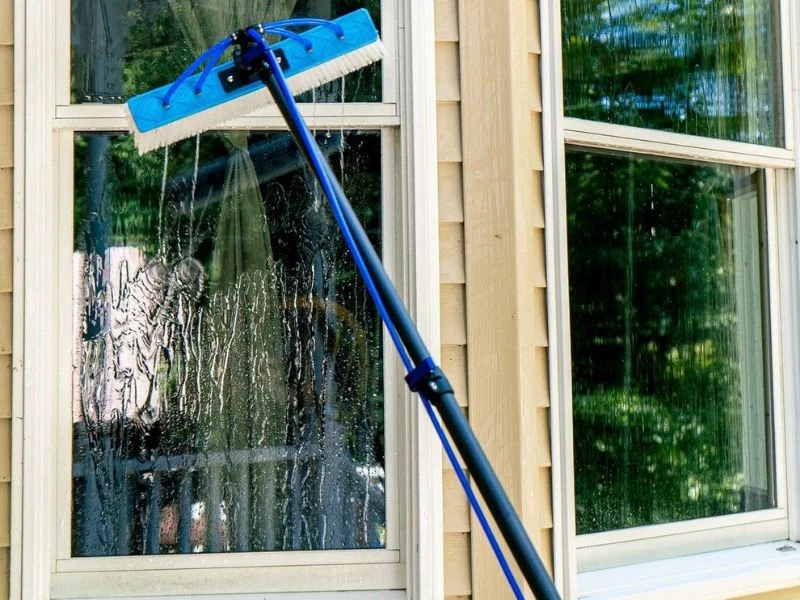 Complete pure water window cleaning system: filtration tank, hose line and water fed pole in use