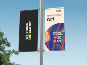 Installer mounting banner brackets on a light pole