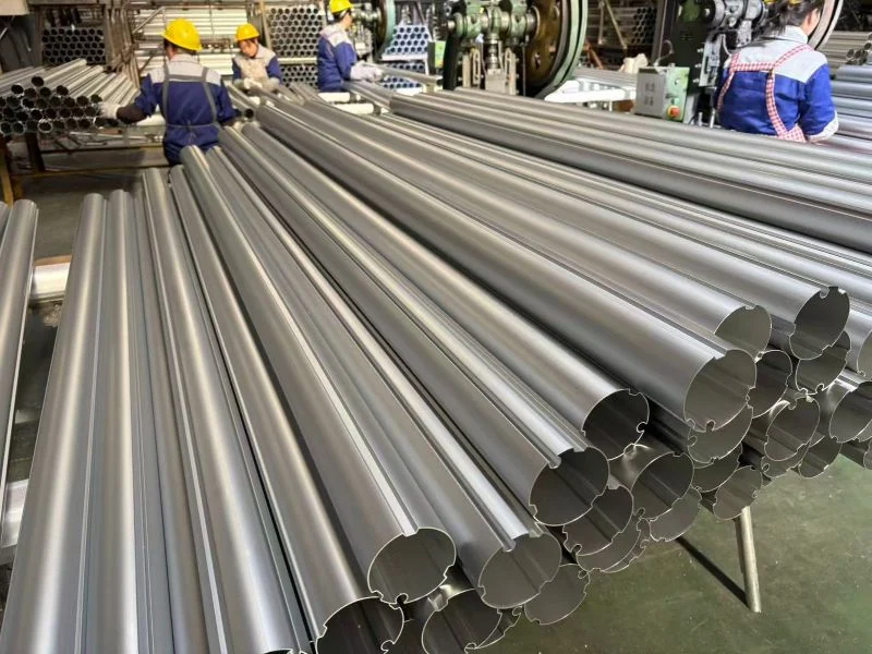 Three cut aluminum tube cross-sections, 32 and 35 mm OD, 1.2 and 1.5 mm walls, beside a caliper